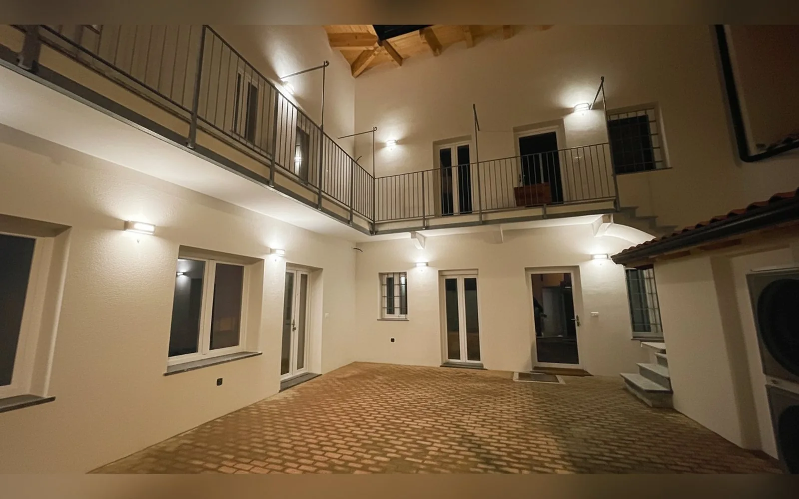 Il cortile interno degli appartamenti COBER IMMOBILIARE a Scarmagno, di sera, con gli accessi indipendenti agli appartamenti